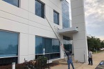 Worker from NIW Services washing office building windows